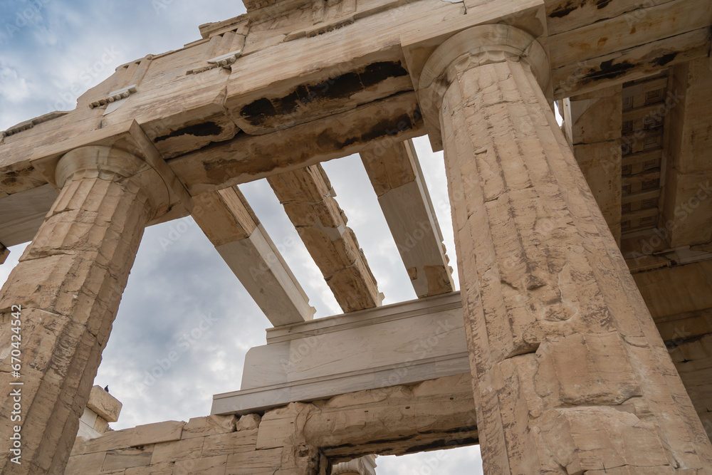 Athenian columns in the Parthenon against the background of the sky with clouds.