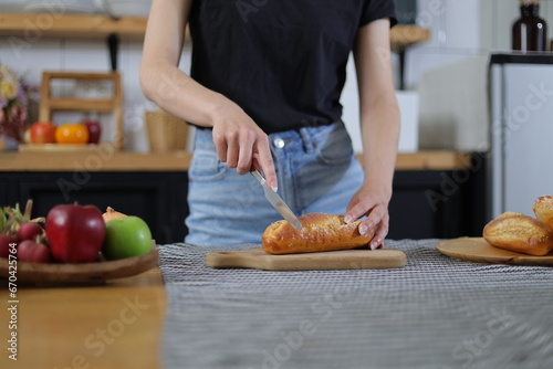 Happy young woman practicing bread making in her home kitchen.