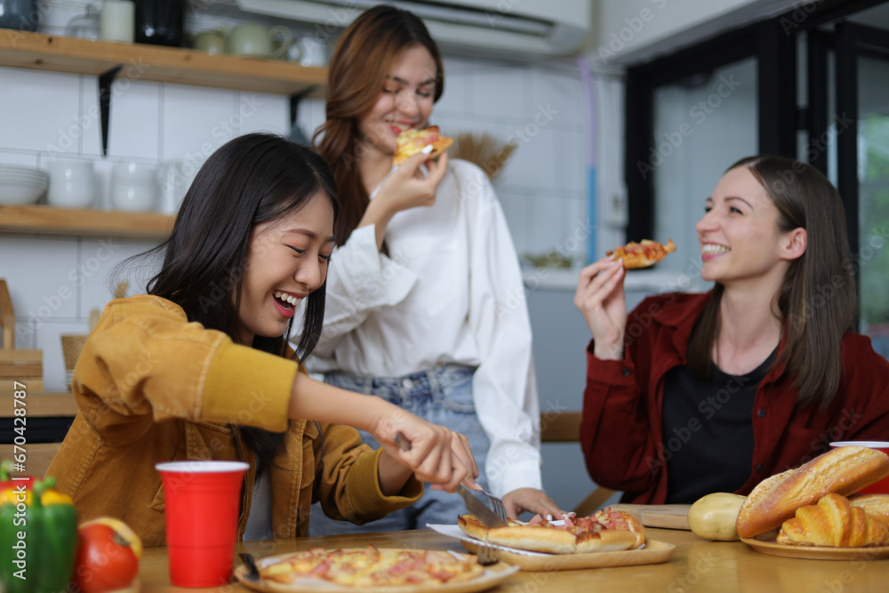 Young woman and friends having a small party in the kitchen at home.