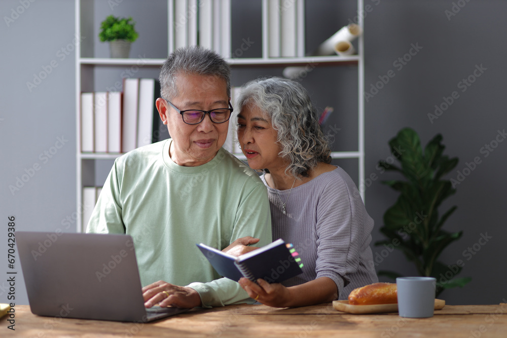 Happy senior couple in retirement at home. Men and women are using laptop in the home office. Happy senior couple in retirement at home. Men and women are using laptop in the home office.