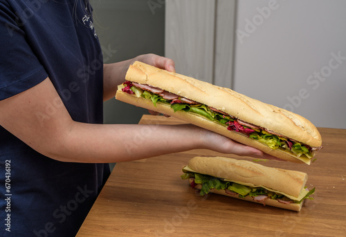 Dziewczyna z ogromną kanapką w rękach 