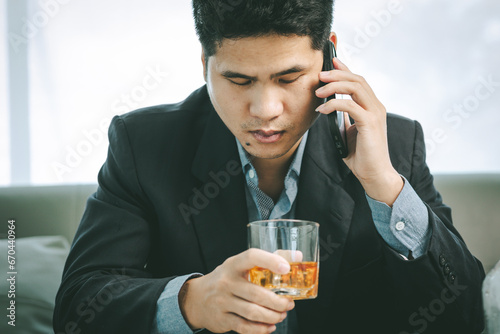 Businessman holding a whiskey glass in a bar or restaurant at night