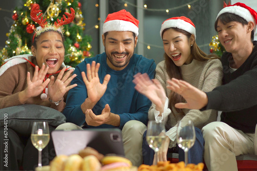 Group of diverse ethnicity young people enjoy celebrating a Christmas and New Year party together with a lot of foods and drinks. Friends celebrate Christmas and New Year festival and drink a wine.