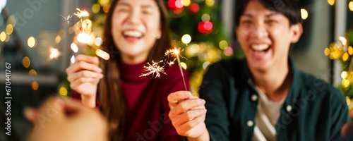 Group of diverse ethnicity young people enjoy celebrating a Christmas and New Year party together with a lot of foods and drinks. Friends celebrate Christmas and New Year festival and drink a wine.