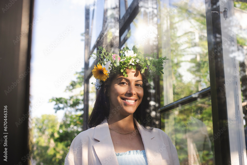 Portrait of smiling woman wearing flower tiara during Swedish midsummer celebration Portrait of smiling woman wearing flower tiara during Swedish midsummer celebration