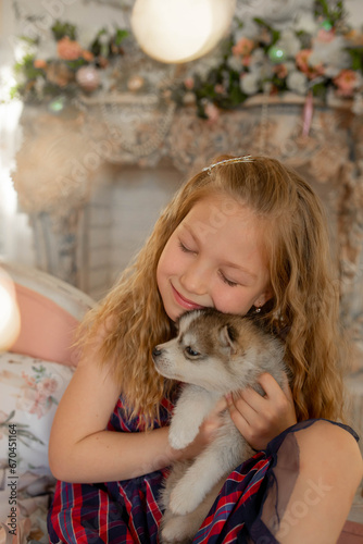 Little happy girl with husky puppy on christmas new year's eve