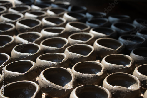 hand made clay lamps, diya, deep kept in sunrise to dry (ID: 670451948)