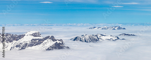 Mountain tops between clouds view from top of Mount Titlis at 3020 meters altitude in Engelberg Switzerland © HildaWeges