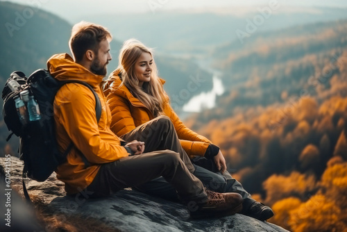 A young couple resting on a rock and enjoying the nature in autumn