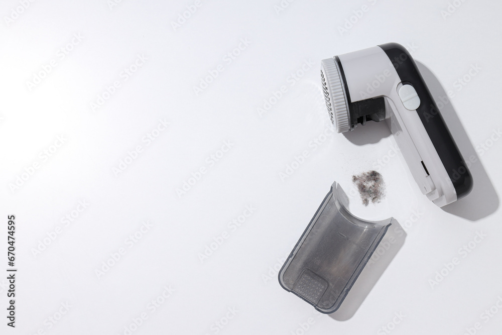 A machine for shaving fabric on clothes, on a light background. A machine for shaving fabric on clothes, on a light background.