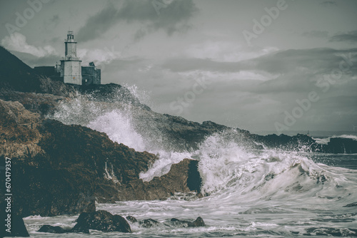 Immerse yourself in the dramatic beauty of Mumbles Lighthouse, where powerful waves crash against the rocks below. The muted colors intensify the somber mood, creating a striking composition capturing photo