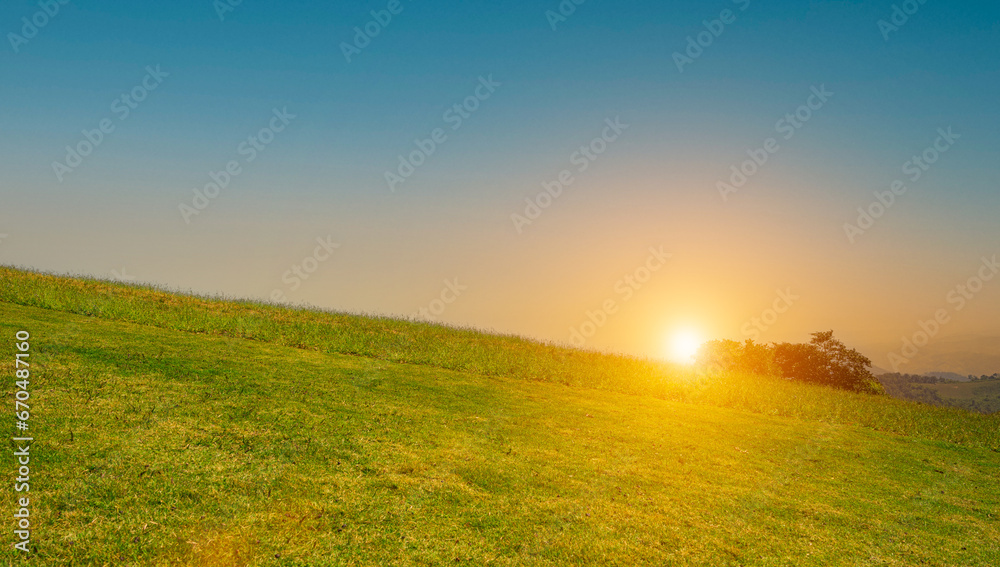 Obraz premium beautiful grass field with sunset or sunrise sky. Countryside landscape view background.