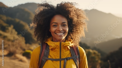 Beautiful african american woman with afro hairstyle, wearing yellow jacket, looking at camera and smiling while standing on top of a mountain Generative AI