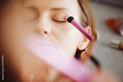 Eyeshadow palette background. Woman holding cosmetics in hand. Girl doing makeup. Premium luxury golden palette. Makeup kit with brush. Multicolor eye shadow. Glamour background. Eyelid brush.