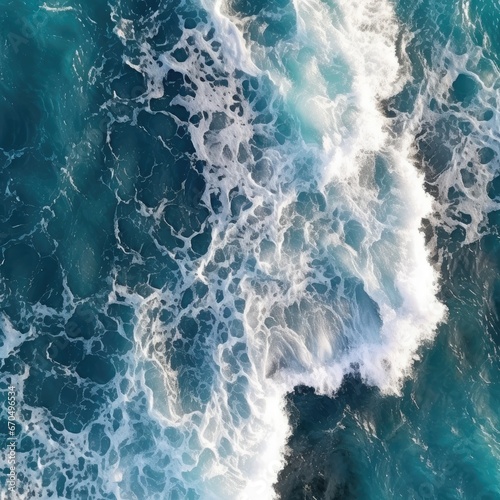 Aerial top view of a breaking ocean wave. Turquoise water with sea foam