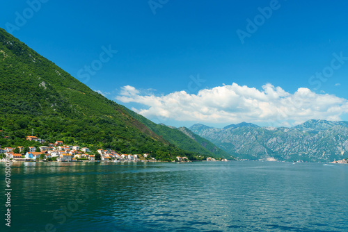 seascapes, a view of the Bay of Kotor during a cruise on a ship in Montenegro, a bright sunny day, mountains and small towns on the coast, the concept of a summer trip