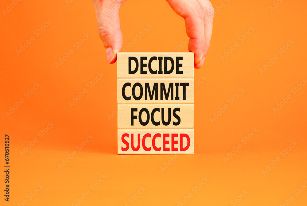 Decide commit focus succeed symbol. Concept word Decide Commit Focus Succeed on wooden block. Beautiful orange background. Businessman hand. Business decide commit focus succeed concept. Copy space. Decide commit focus succeed symbol. Concept word Decide Commit Focus Succeed on wooden block. Beautiful orange background. Businessman hand. Business decide commit focus succeed concept. Copy space.