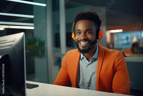 African American business man wearing telephone headset talking to caller in customer services department. Friendly black call center agent working in front of computer in modern office.