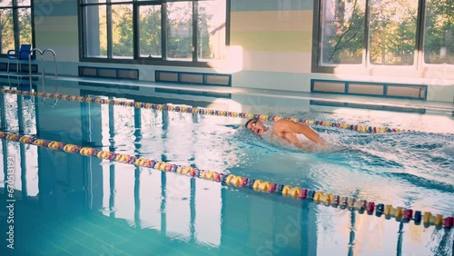 Wallpaper Mural Young swimmer trains actively on lane in clear swimpool Torontodigital.ca