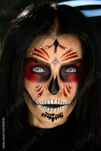 portrait of a person with scary halloween mask vampire with skull in dark studio. Santa de muerte conseption. 