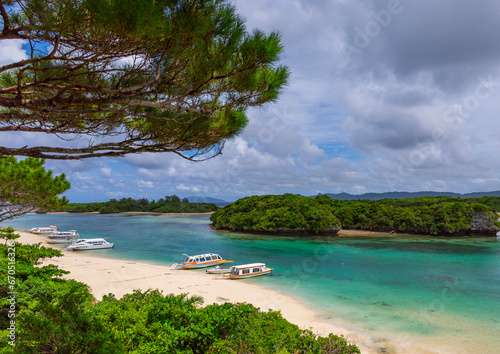 Glass bottom boats in tropical lagoon with clear blue water in Kabira bay, Yaeyama Islands, Ishigaki, Japan photo