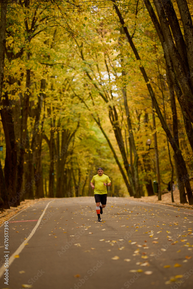 Portrait of a middle-aged man running in the park on an autumn day. Portrait of a middle-aged man running in the park on an autumn day.