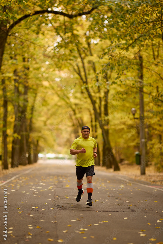 Portrait of a middle-aged man running in the park on an autumn day. Portrait of a middle-aged man running in the park on an autumn day.
