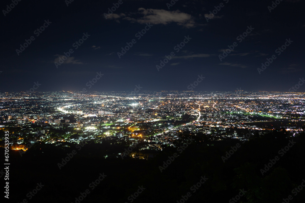 Chiang Mai night city view from the slopes of Doi Pui mountain on the way to the famous Doi Suthep temple, North Thailand.