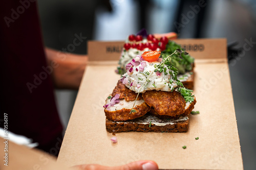 Danish open sandwich made of rye bread, meatballs and sauce, man buying fast food meal. photo