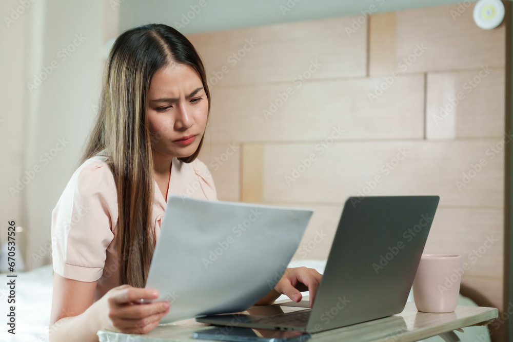 Time to work from home, beautiful Asian woman with long hair Sitting on a laptop computer typing documents on the bed in the bedroom Prepare to send meeting minutes to supervisors on holidays. Time to work from home, beautiful Asian woman with long hair Sitting on a laptop computer typing documents on the bed in the bedroom Prepare to send meeting minutes to supervisors on holidays.