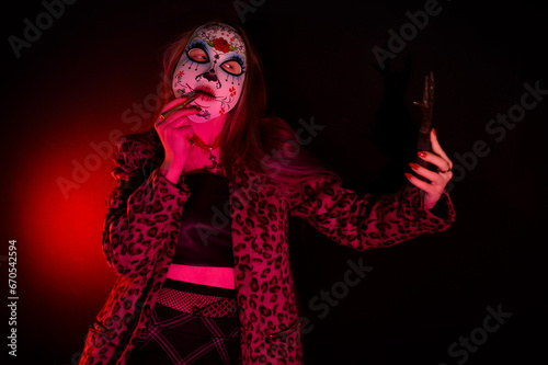 A fashion-forward woman with masquerade mask  poses in a leopard print coat, immersed in neon light, embodying a fusion of mystery and style