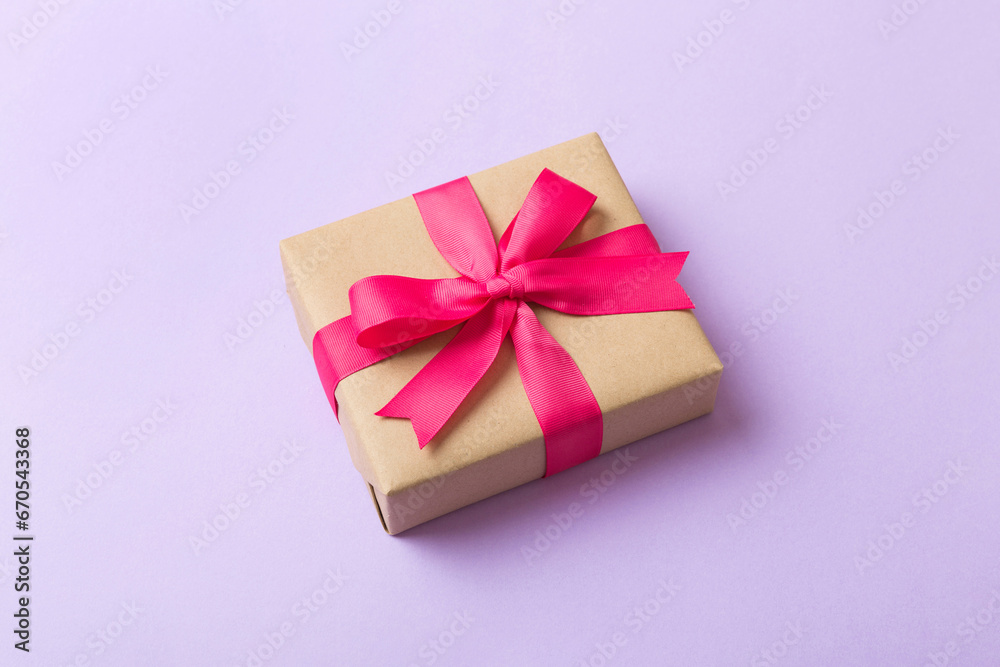 Wrapped christmas or other holiday handmade present in craft paper with colored ribbon. Present box, decoration of gift on table, top view with copy space Wrapped christmas or other holiday handmade present in craft paper with colored ribbon. Present box, decoration of gift on table, top view with copy space