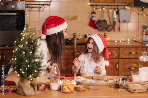 Making gingerbread at home. Little girl cutting cookies of gingerbread dough. Christmas and New Year traditions concept. Christmas bakery. Happy holidays © Aleksandr