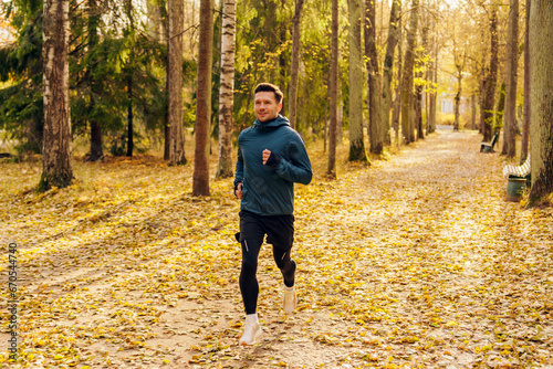 A confident and hardy man running alone. A running coach does a jogging exercise in athletic shoes. An athlete leading an active and healthy lifestyle on weekends in the park. photo