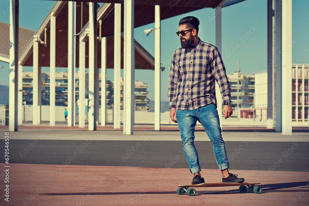 Obraz premium Skilled male skater riding longboard at city skate park