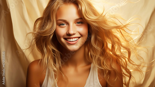 Beautiful woman with blonde hair covers on a beage studio background photo