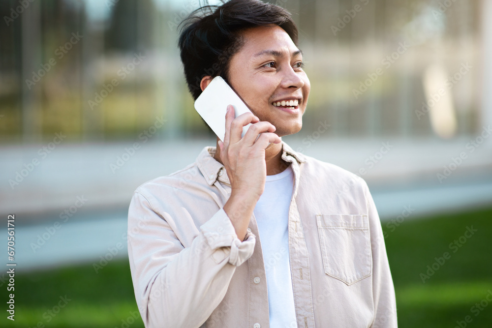 Portrait of cheerful asian guy have phone conversation Portrait of cheerful asian guy have phone conversation