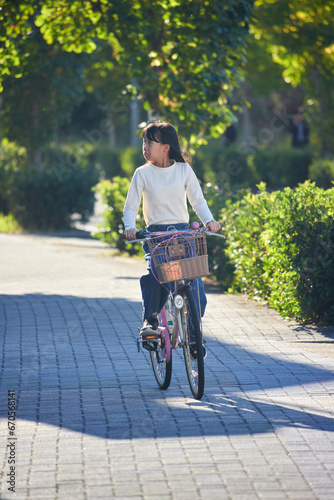 秋の夕方の街で自転車を乗っている小学生の女の子の様子