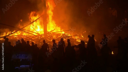 Silhouettes of people gathering around the (supposedly sacred) remains of Dussehra effigies, set on fire in Amritsar, India photo