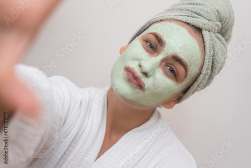 Joyful Snapshot: Wrapped in a bathrobe, she takes a selfie with a clay mask, exuding happiness in every pixel. 