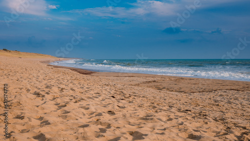 Fototapeta Naklejka Na Ścianę i Meble -  A golden hour by the Atlantic, a sandy beach with almost no people.