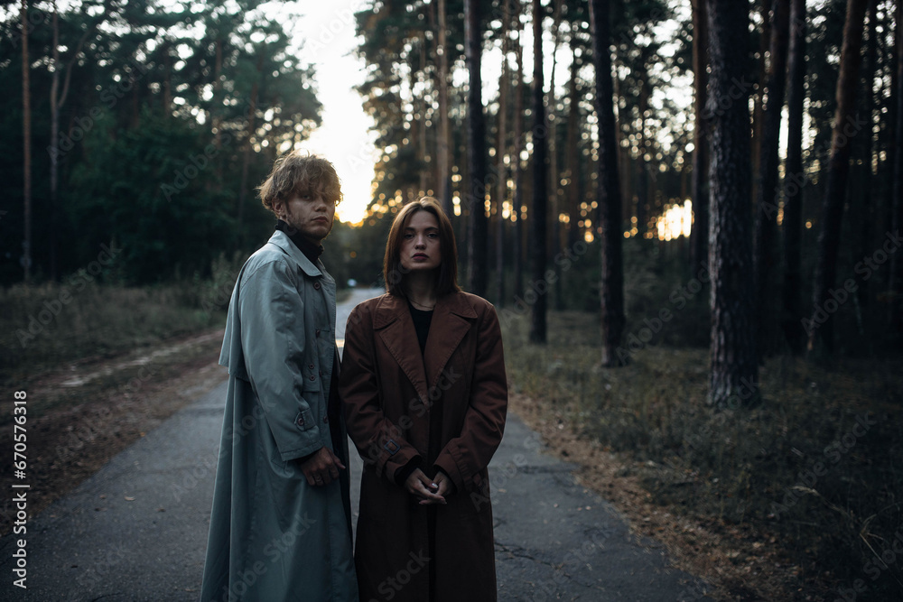 Fototapeta premium romantic couple in the forest in a coat, gloomy date sadness and peace.