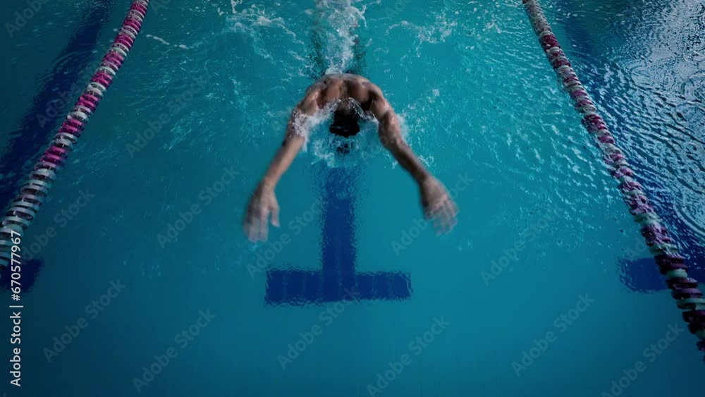 Swimmer trains butterfly style for performance in pool