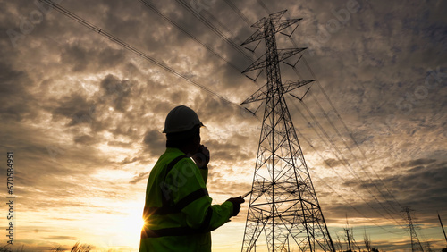 Silhouette of engineer man checking high-voltage power lines. photo