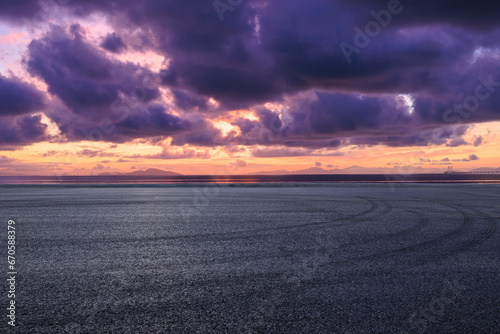 Asphalt road and coastline with colorful sky clouds at sunrise