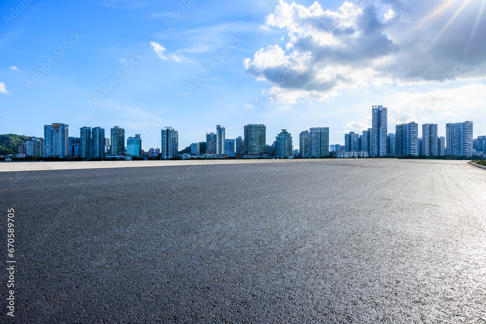 Asphalt road and residential area buildings under blue sky