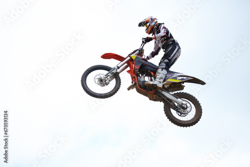 Person, motorcycle and air jump adventure as professional in action, competition or fearless. Bike rider, off road transportation stunt or fast speed blue sky or rally, extreme sport or challenge