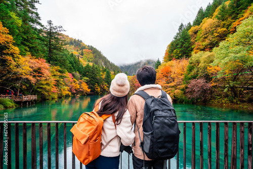 Young couple tourist looking at beautiful autumn scenery landscape at jiuzhaigou national park in Chengdu, China photo