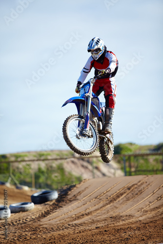 Person, motorcycle or bike hill jump as professional in action danger competition, fearless or race risk. Rider, off road transportation or fast speed dirt adventure or rally, extreme sport or gear