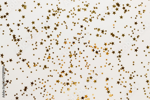 Golden confetti stars background on white wooden backdrop. Golden stars glitter background for template and design. Christmas  event  party  birthday holiday and New Year concept